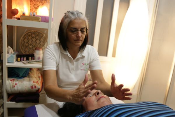 Viviana Althaus Peralta haciendo una sesión de reiki a una clienta en su consultorio de Sant Celoni